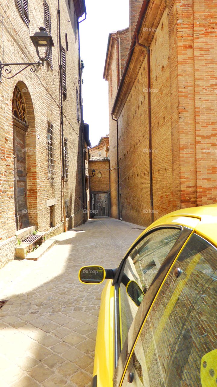 Car is little road. This car is throwing into a small hole in an ancient town