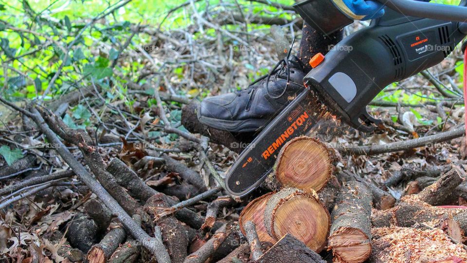 Cutting logs with a Remington electric chainsaw