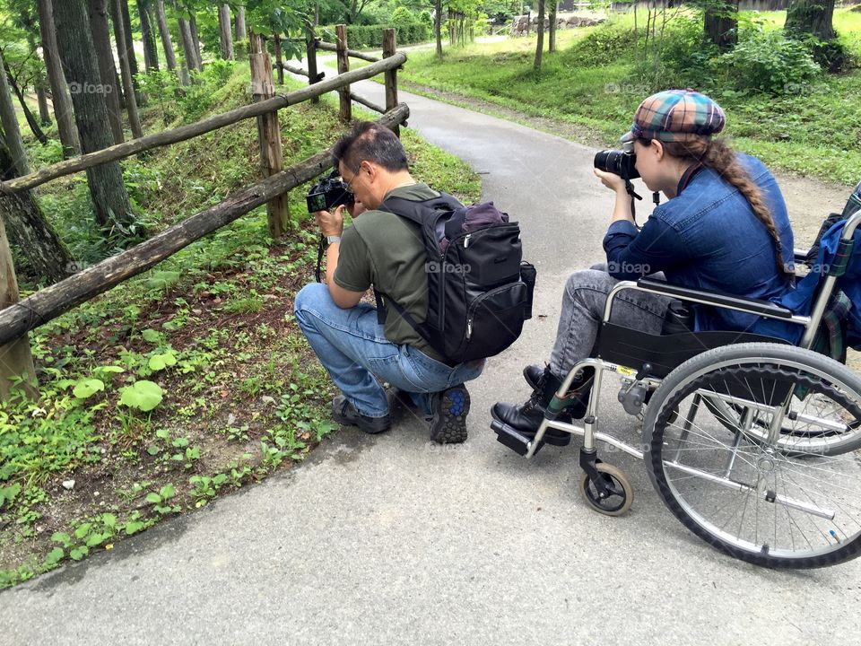 Two people capture different angles of the same view with their cameras