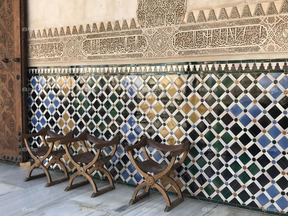 Antique seating against the tiled walls of Alhambra 
