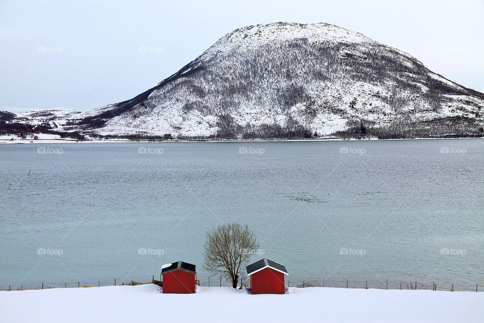 Two red shelters in a winter landscape.