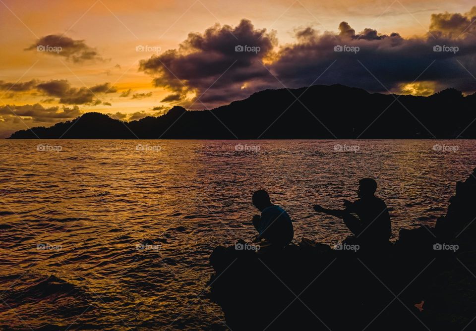 Silhouette of Asian People's fishing in sunset at summer