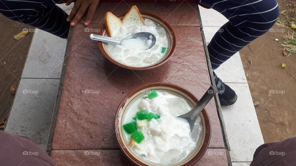 green banana ice, which consists of a variety of marrow porridge, pudding, ice cubes, plain bread, nuts, bananas cut into small pieces, is a delicious and cheap drink in Indonesia.