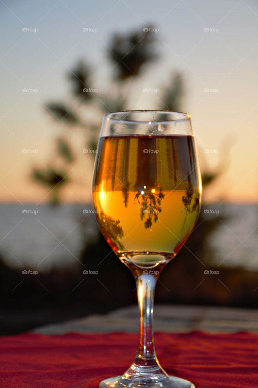 Liquids are cool - A glass of wine with a reflection. As with almost all things in life, a good sunset can be made even better with the right glass of wine. 