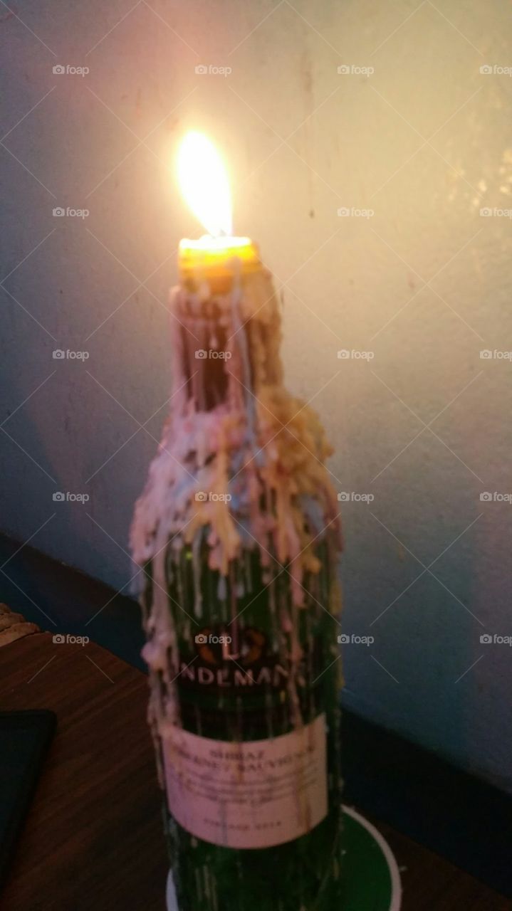 Lit color array. My camera phone shot this bottle candle during dinner at our table in Rotterdam, Netherlands. Our first trip to The Ned