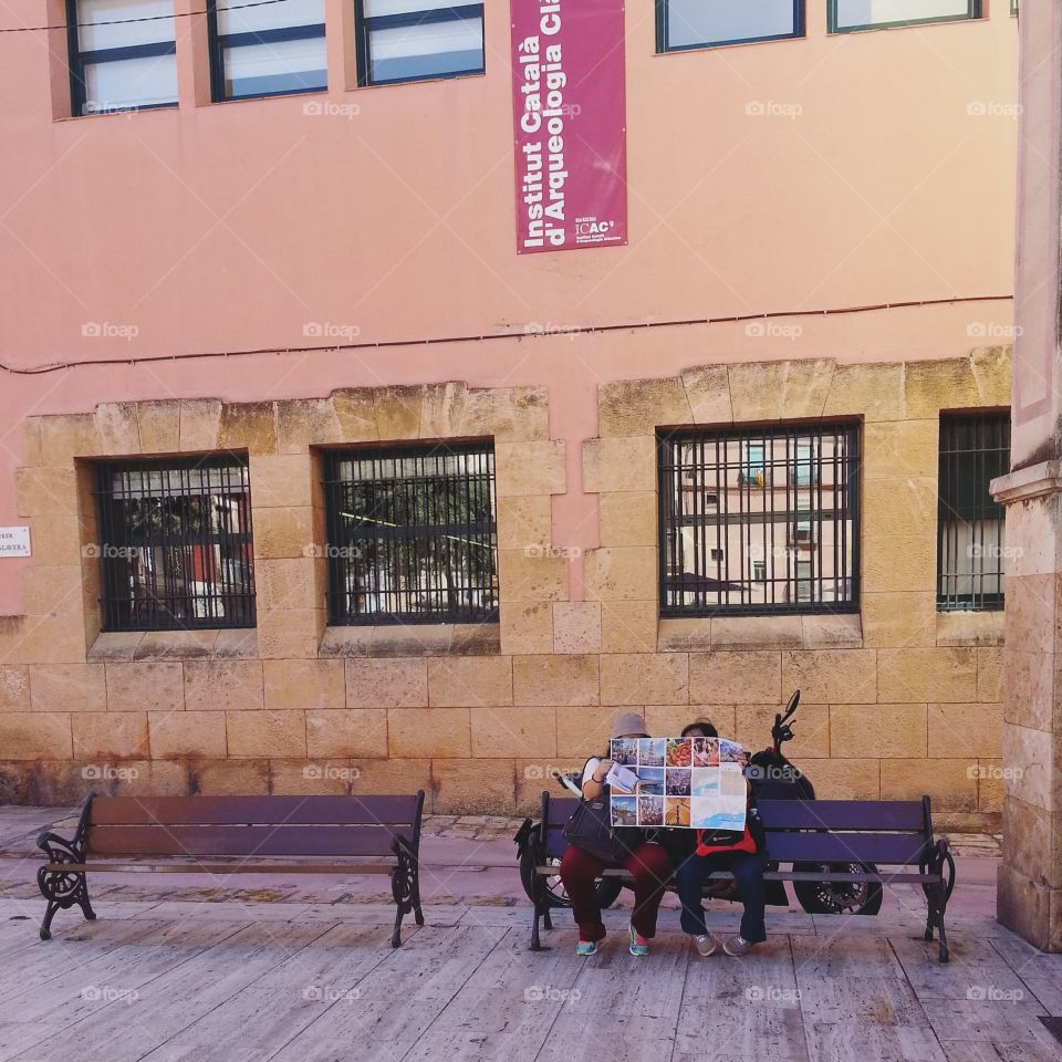 Tourists study a route according to Tarragona on the map