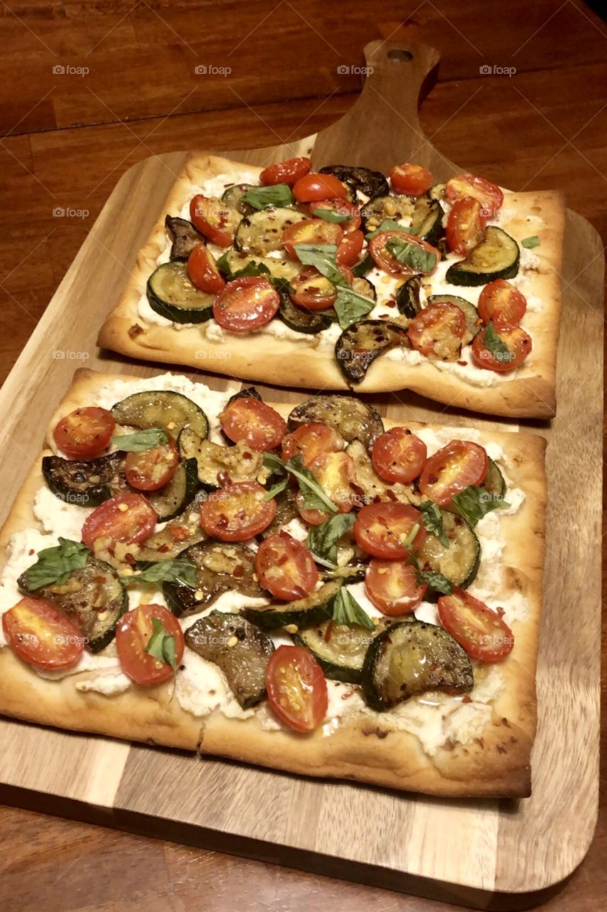 Yummy zucchini, tomato, basil, and honey on top of a ricotta covered flatbread. 