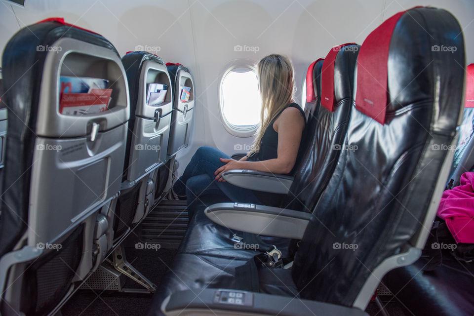 Woman looking out the window on a airplane.