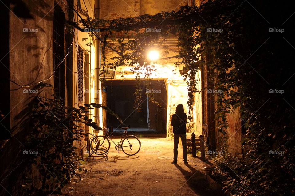 Lonely silhouette of a man and bike in the yard