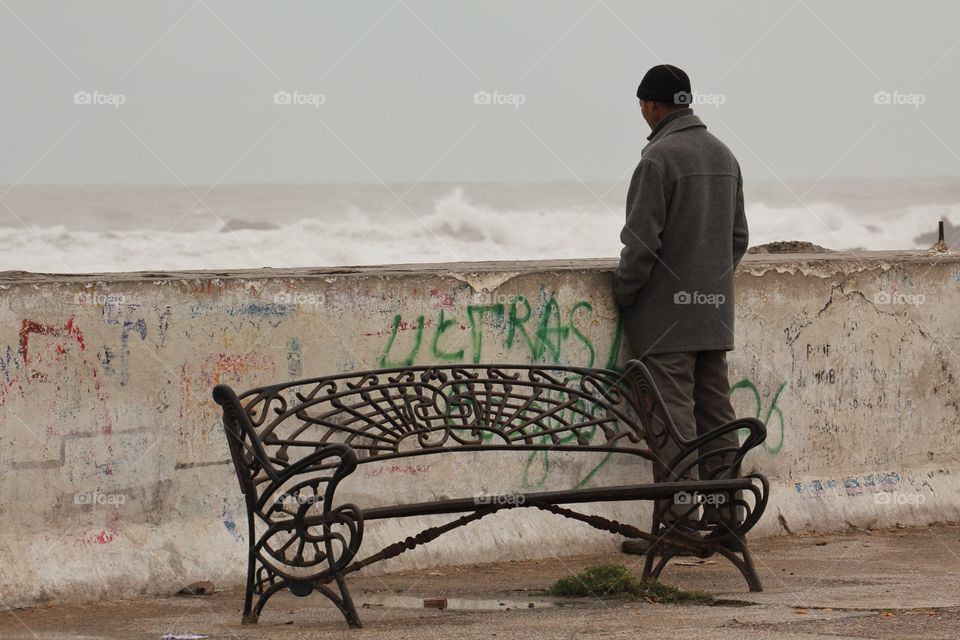 Man looking off into the distant waves 