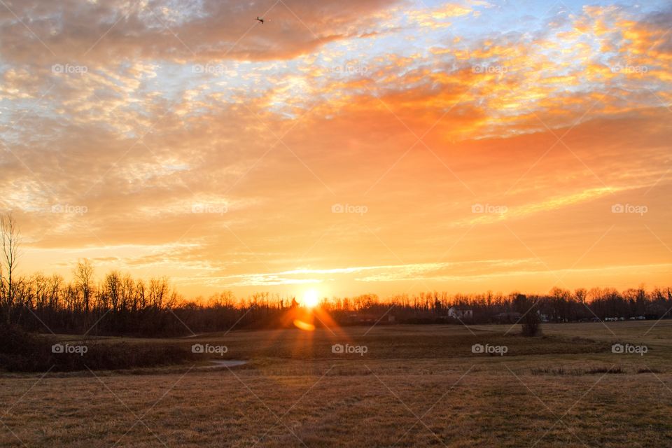 Sunset on my countryside while an airplane flies in a cloudy sky,Italian landscape