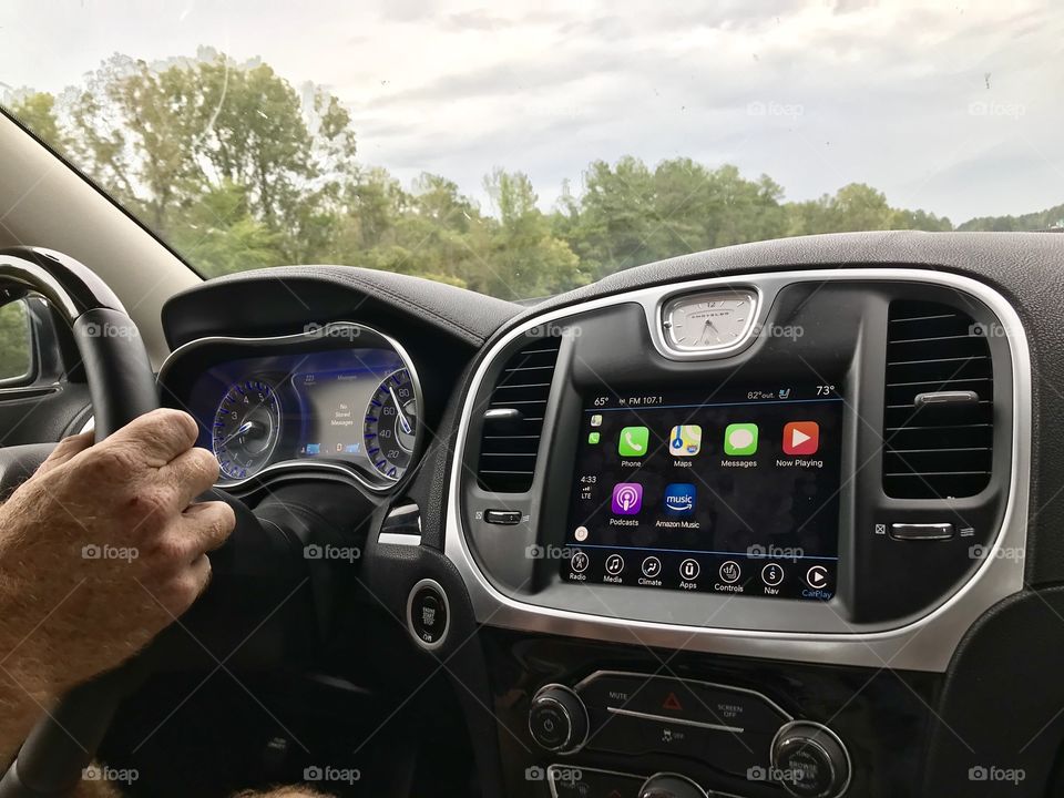 Man driving a new car with a touch screen computer dashboard