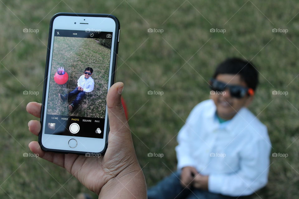 Happy kid through tech screen of mobile 