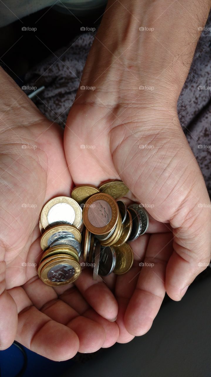 Moedas nas palmas das duas mãos.