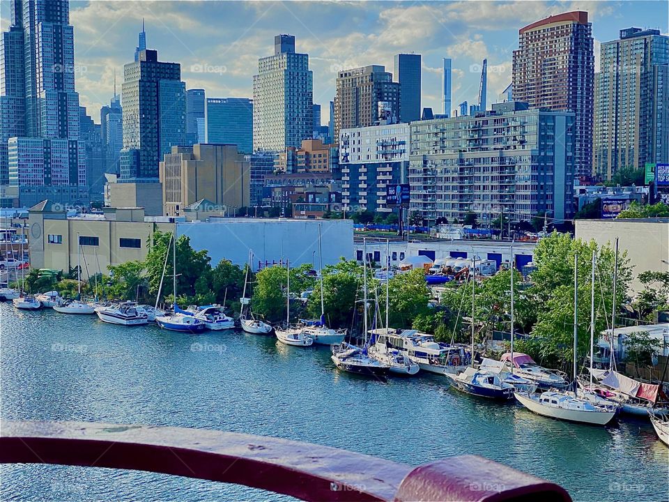 Then there’s something as exiting as this view of the “E River” & two NYC boroughs. Nearest is LIC, Queens and further away behind it is “Manhattan”. Most idyllic are the boats against the tree lined LIC shore & the ocean. 2022. Hypnotic Productions