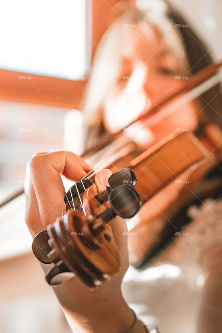 A girl play the violin in the house