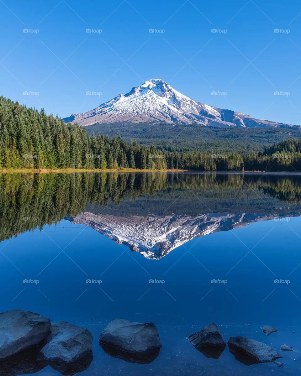 Pristine mountain landscape reflecting over tranquil lake on beautiful blue sky morning. Mt Hood, Oregon. 