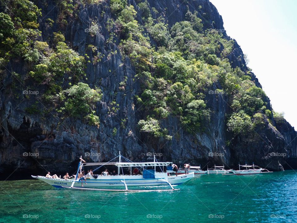 Limestone cliff and a boat with tourists