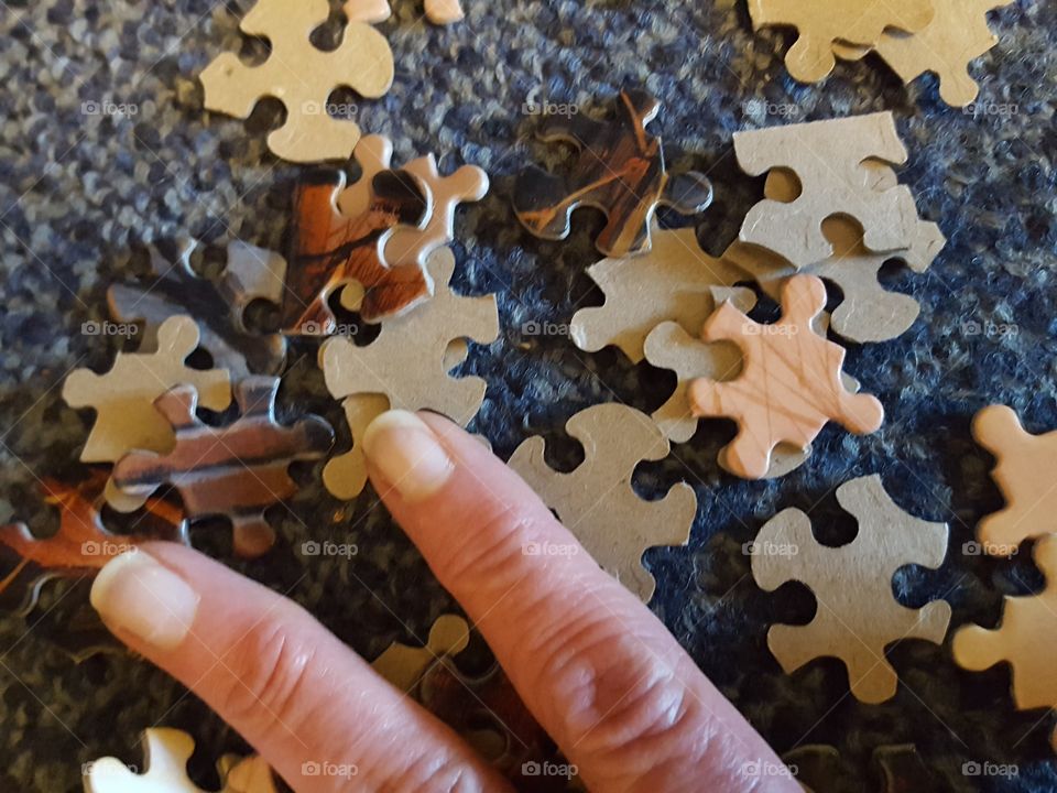 Directly above view of puzzle with human finger