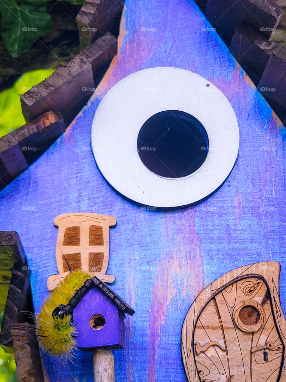 bright yellow and fuzzy caterpillar hanging out on a bright purple house.