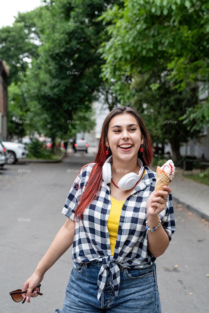 happy woman eating ice cream at the street