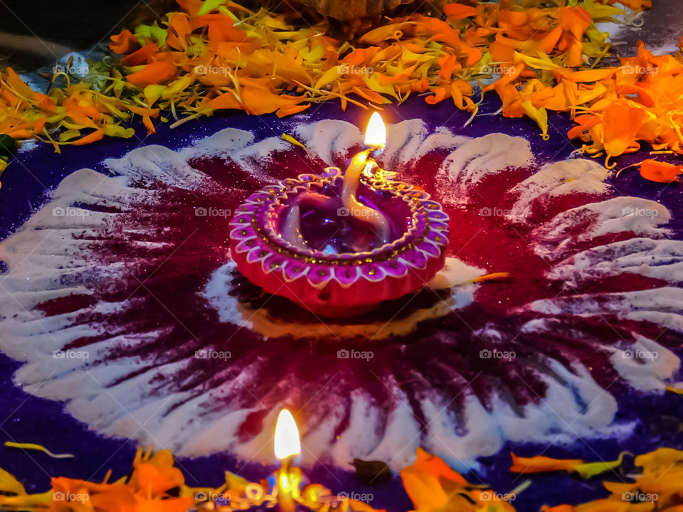 Colourful diya or oil lamp with design which is put on Rangoli and flower petals design. It is used in Indias biggest festival DIWALI for decoration. looking attractive.