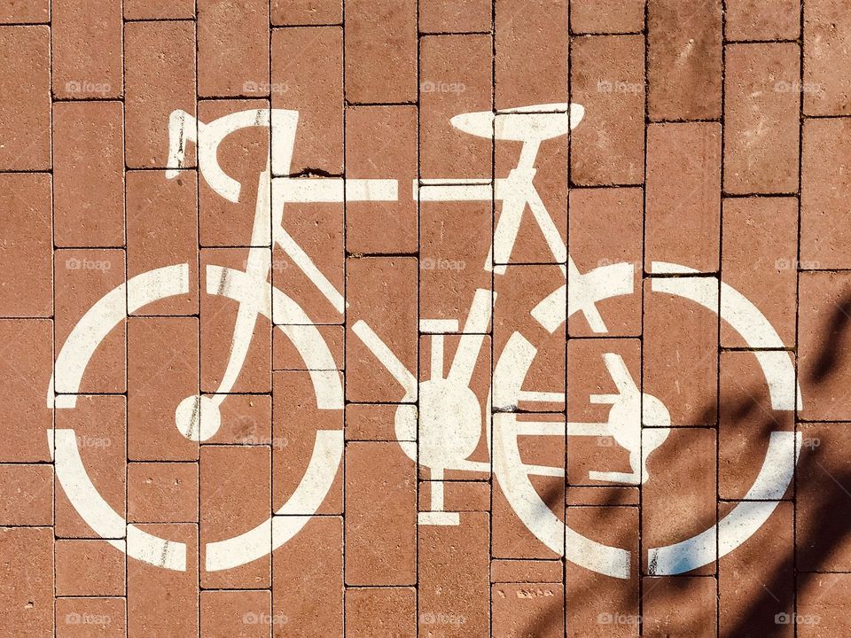 Bicycle sign on a path made of red rectangular stones