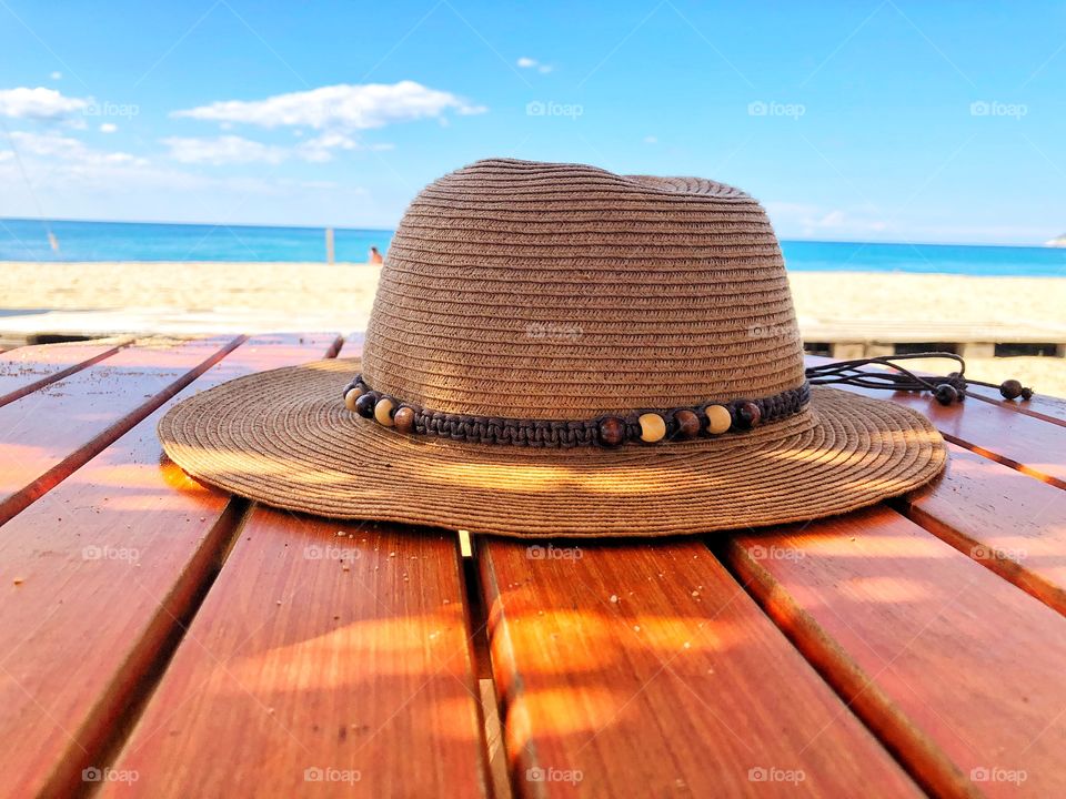 Summertime essential, hat on a table at the beach