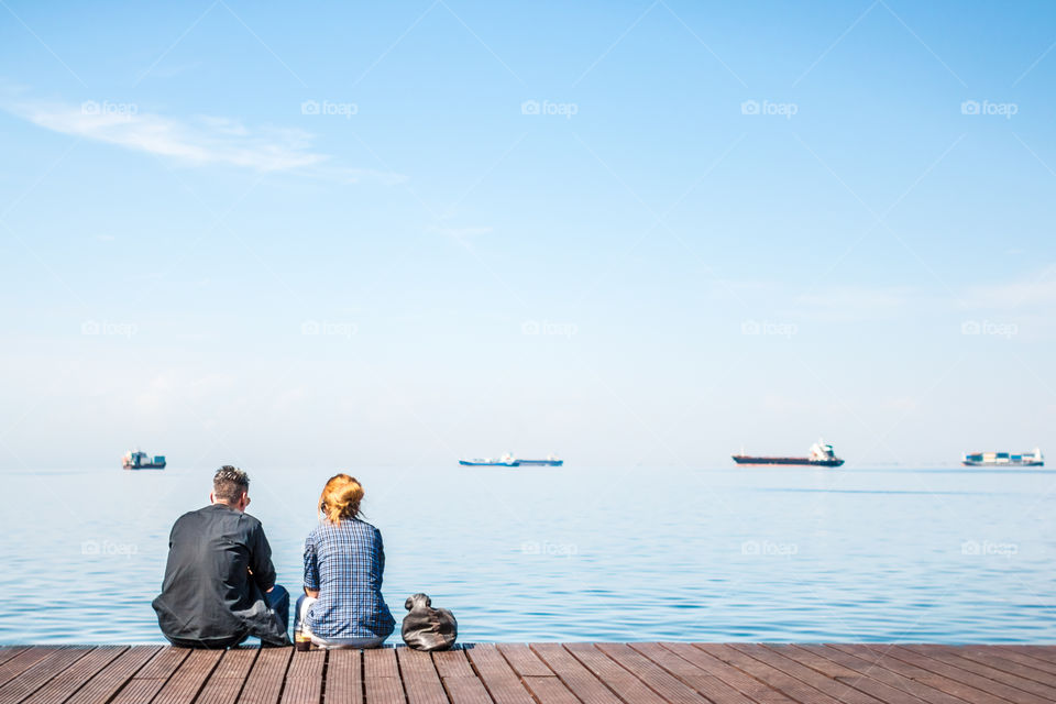 Friends Sitting On The Dock
