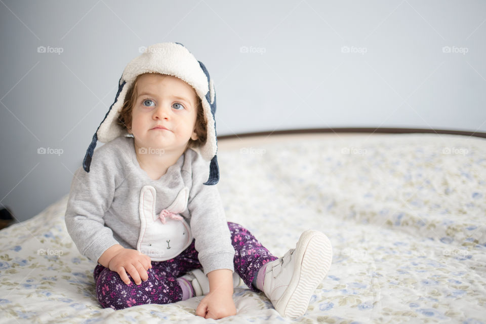 Cute baby sitting on bed