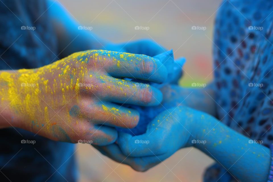 Hands covered blue holi paint