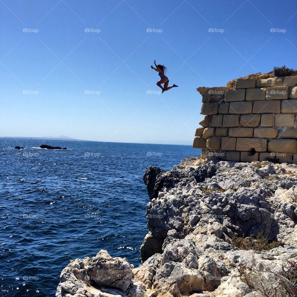 Woman jumping from cliff