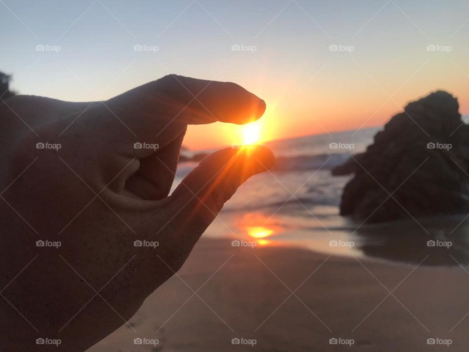 the sun in your hands, so close and yet so far, a magical sunset from the beach