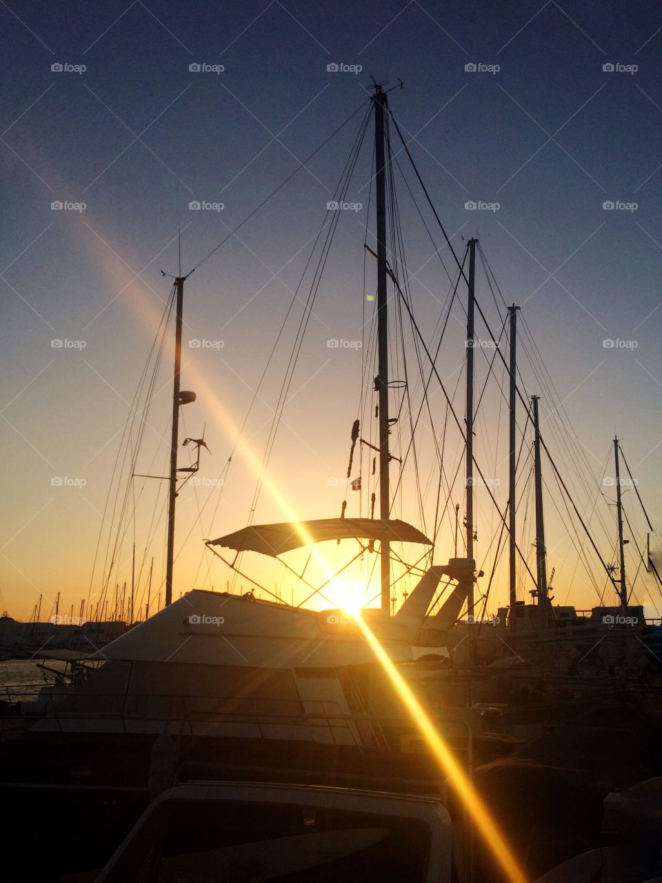 sun rays from behind the boats. boats at sunset with rays from behind the shadows 