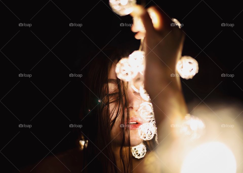 Brunette girl in twinkly moody lighting. 