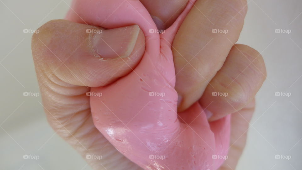 hand squeezing pink dough