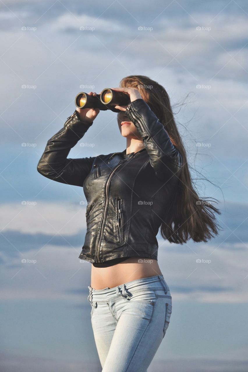 Young woman looking through binocular