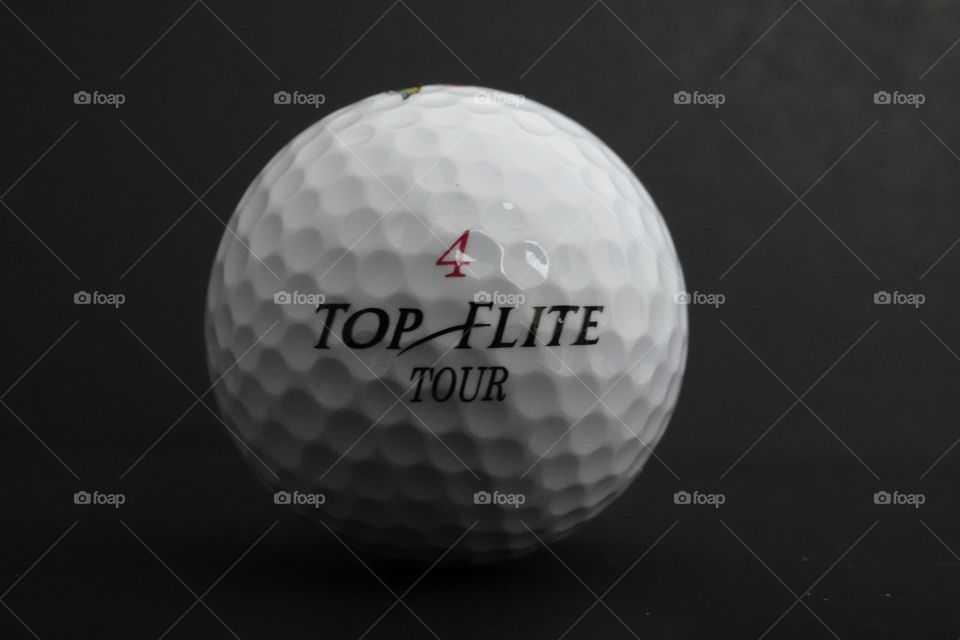 Top Flite 4 golf ball against black background