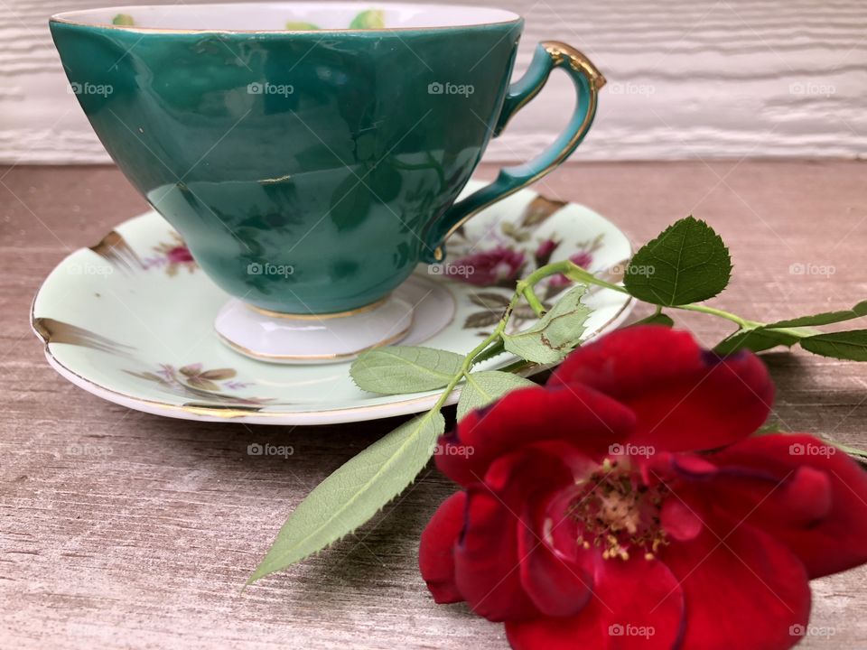 Fancy teacup with rose beside it