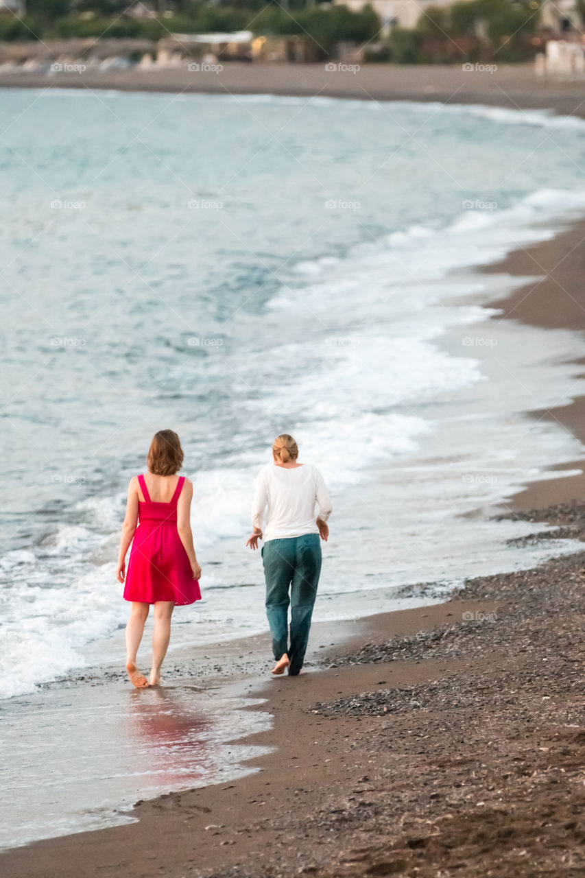 Friends Walking And Talking At The Beach