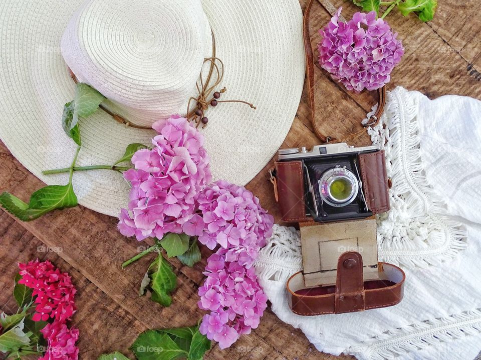 Still life with old camera and summer hat