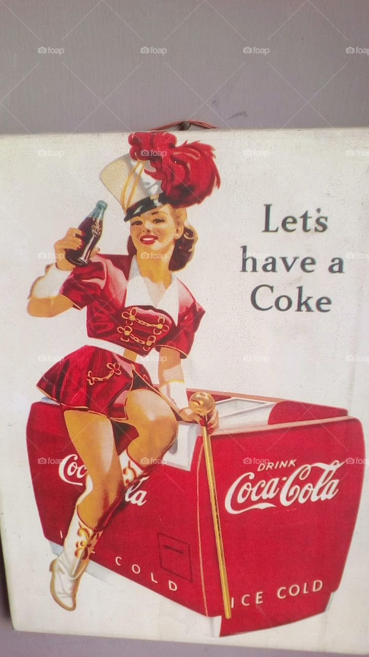 Old promotion of Coca Cola#
Pretty happy young women sit on Coca Cola
red big frigider with Coca Cola full bottle 
in her hand