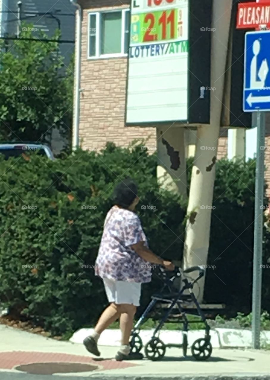 Senior Citizen walking with Walker in City.