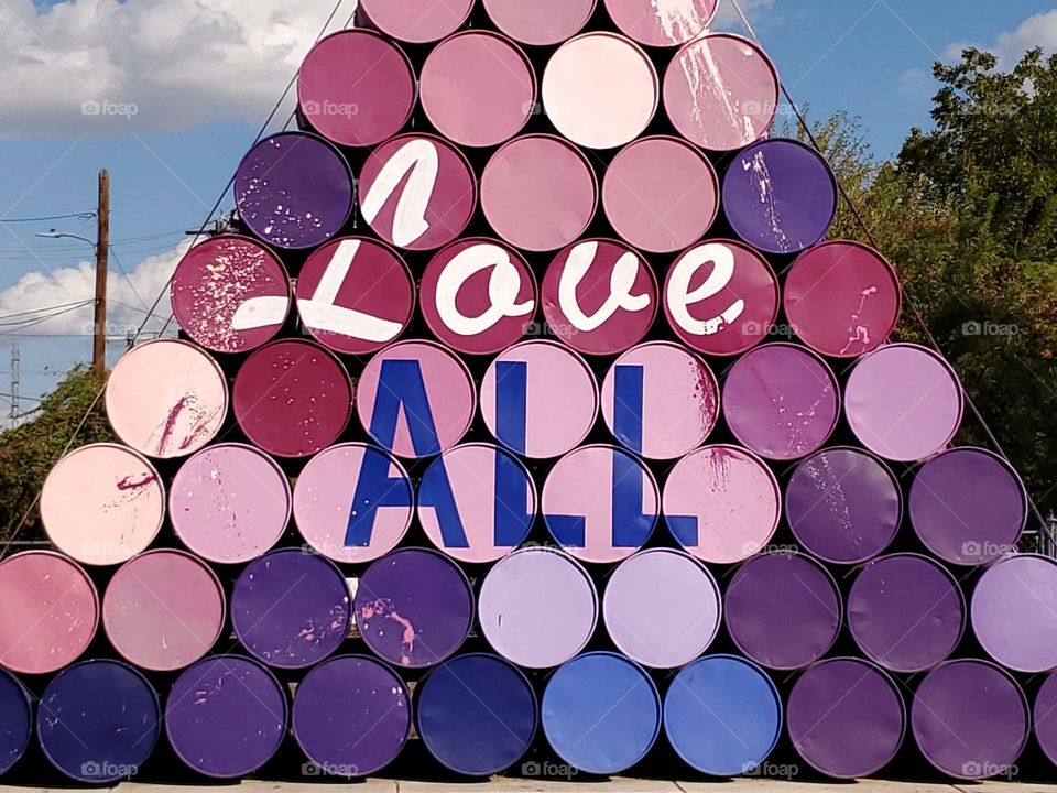 Circles:  Stacked painted barrels with the words Love ALL.