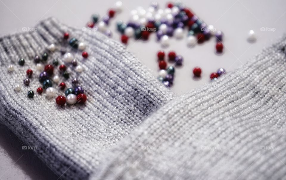 Beads needlework bijouterie multicolors textured beauty close-up winter light mittens gray color background