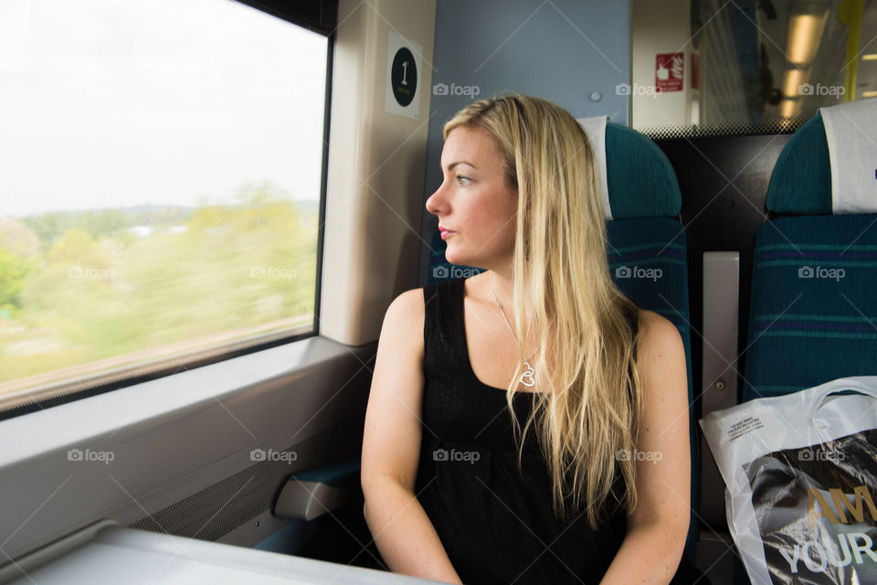 Woman looking out the window on the train from Gatwick Airport to London.