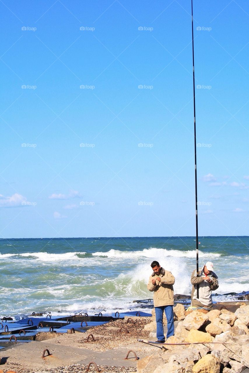 Men fishing in a choppy coast
