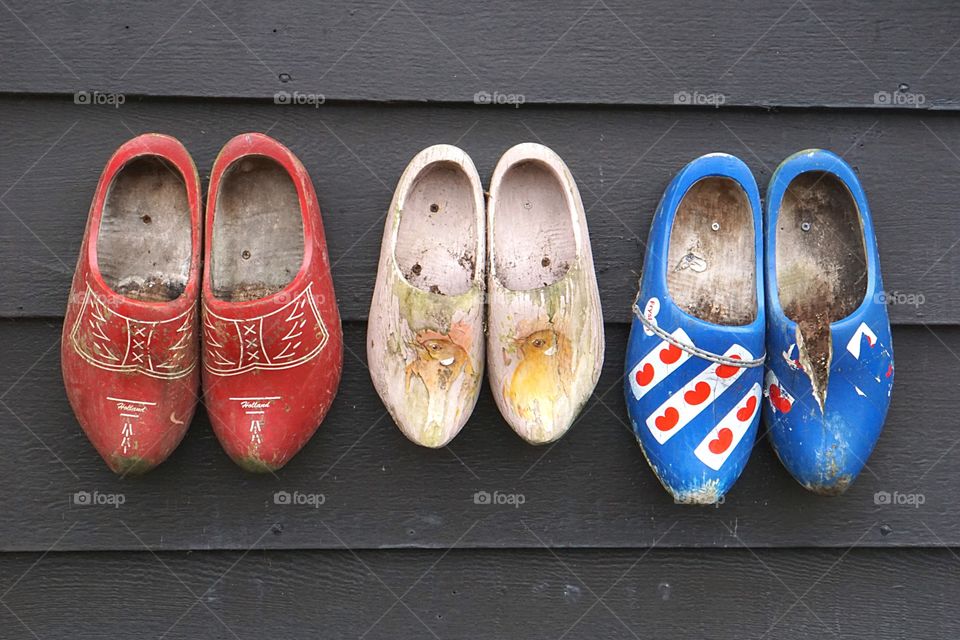 Wooden clogs on a gray wall