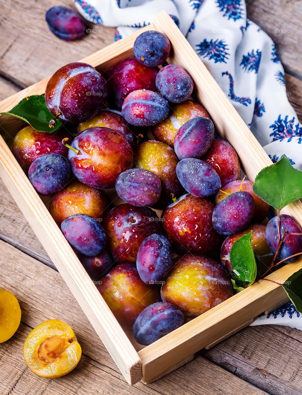 Overhead view of a crate of plums
Overhead view of a crate of plums on the wooden surface.