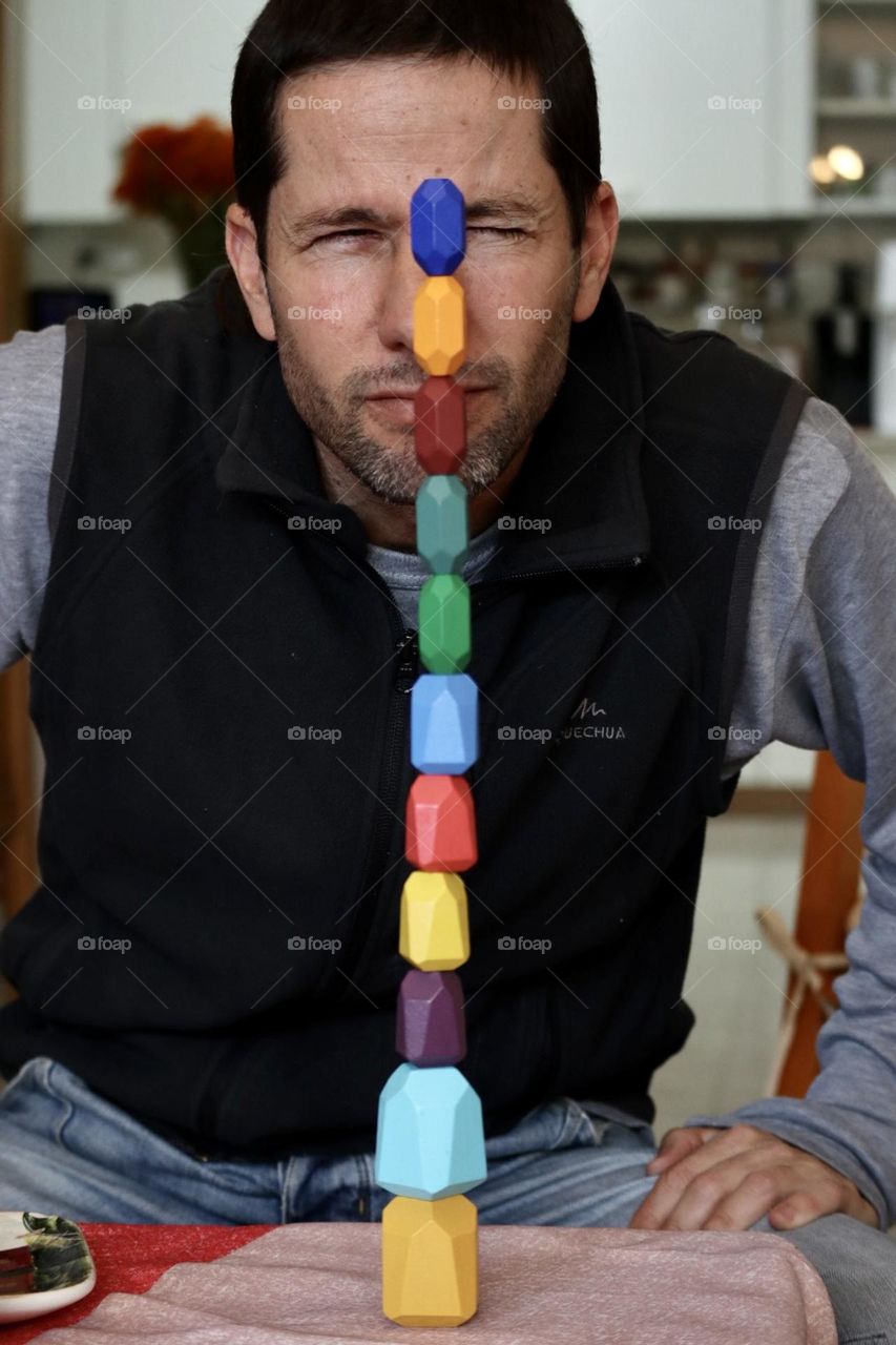 Father playing with his kids blocks, show them he made the highest tower 